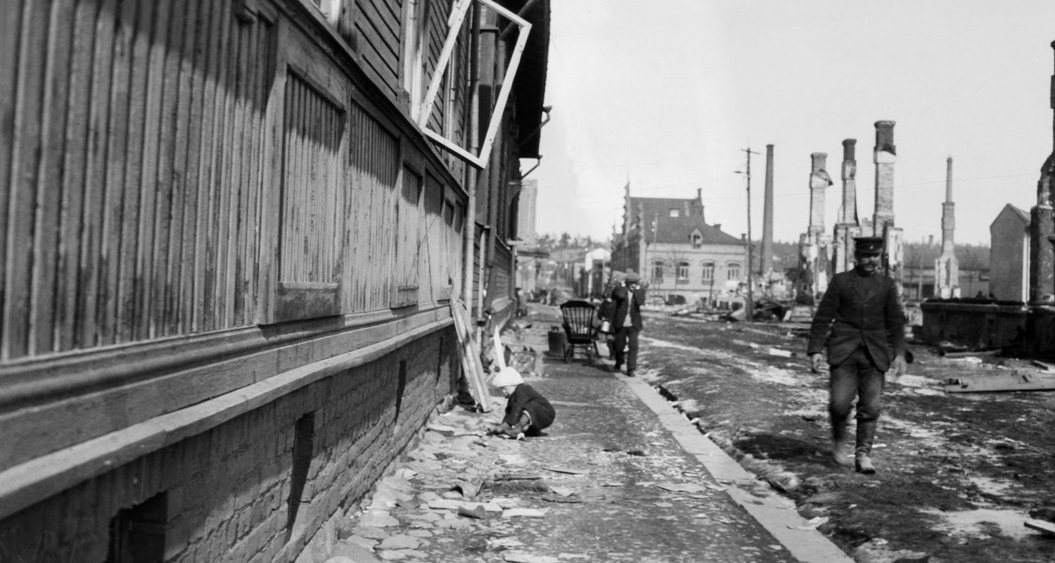 Lapsi leikkii kadulla pian Tampereen taistelun päättymisen jälkeen. Kuva on otettu Tammelan kaupunginosassa Aaltosenkadulla 10.4.1918. Kuvaaja Oscar Sundberg, Vapriikin kuva-arkisto 